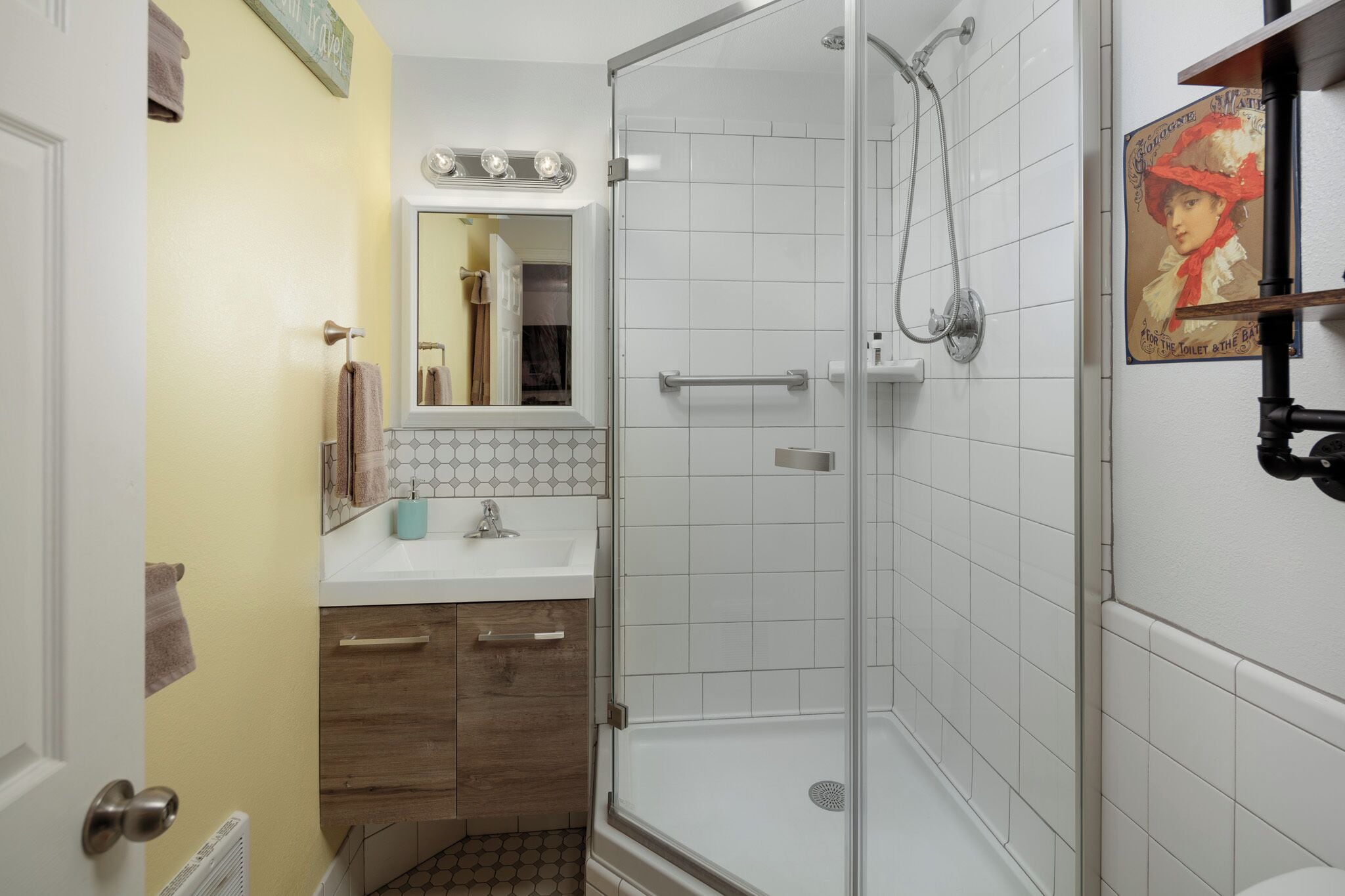 Un bagno con doccia, lavandino e specchio.