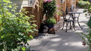 Une maison avec une terrasse en bois, un pot de fleurs et une table avec des chaises.