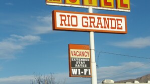 En skylt för ett motell med orden ”MOTEL” och ”RIO GRANDE” skrivna på den.