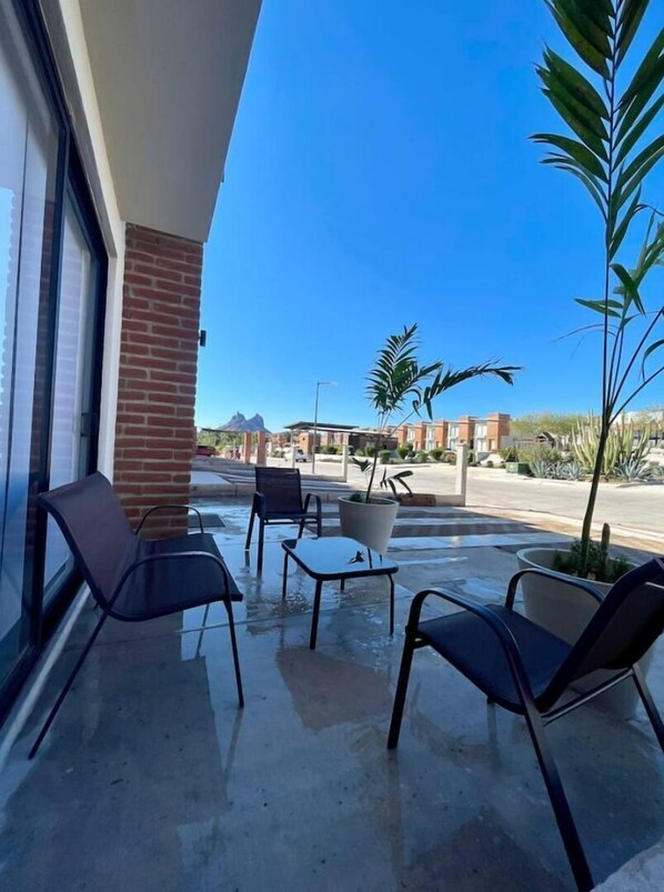 Guests can sit and enjoy the fresh air in this outdoor seating area with a brick building backdrop.
