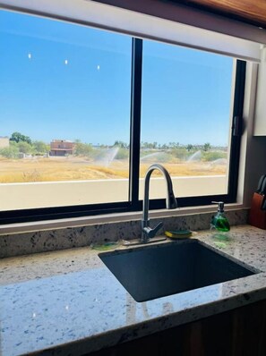 Enjoy a view of the surrounding countryside from this kitchen's large window.