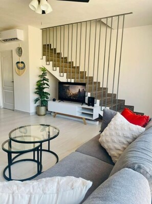 Relax in this stylish living room with a sofa, coffee table, and flat-screen TV.