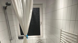 Un bagno piccolo con vasca, water e lavandino.