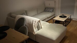 Un soggiorno moderno con un divano, un tavolino da caffè e un'area pranzo con tavolo e sedie.