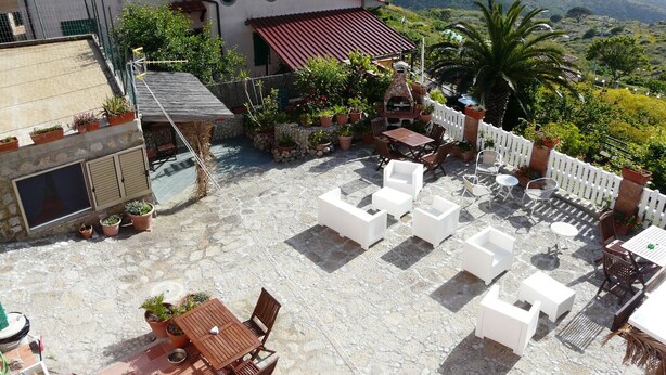 A patio with outdoor seating, a barbecue area, and potted plants. - Studio apartment in Isola del Giglio locality Castello (Giglio Castello)