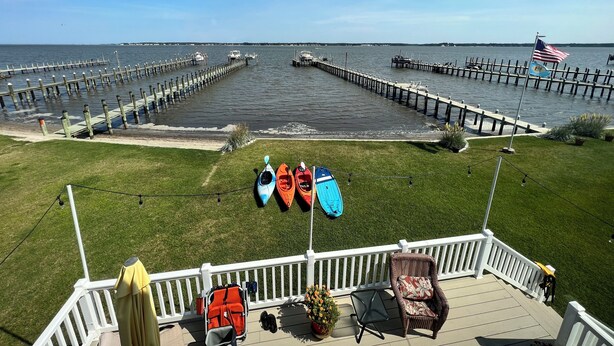 A deck with kayaks, a chair, and a flag.