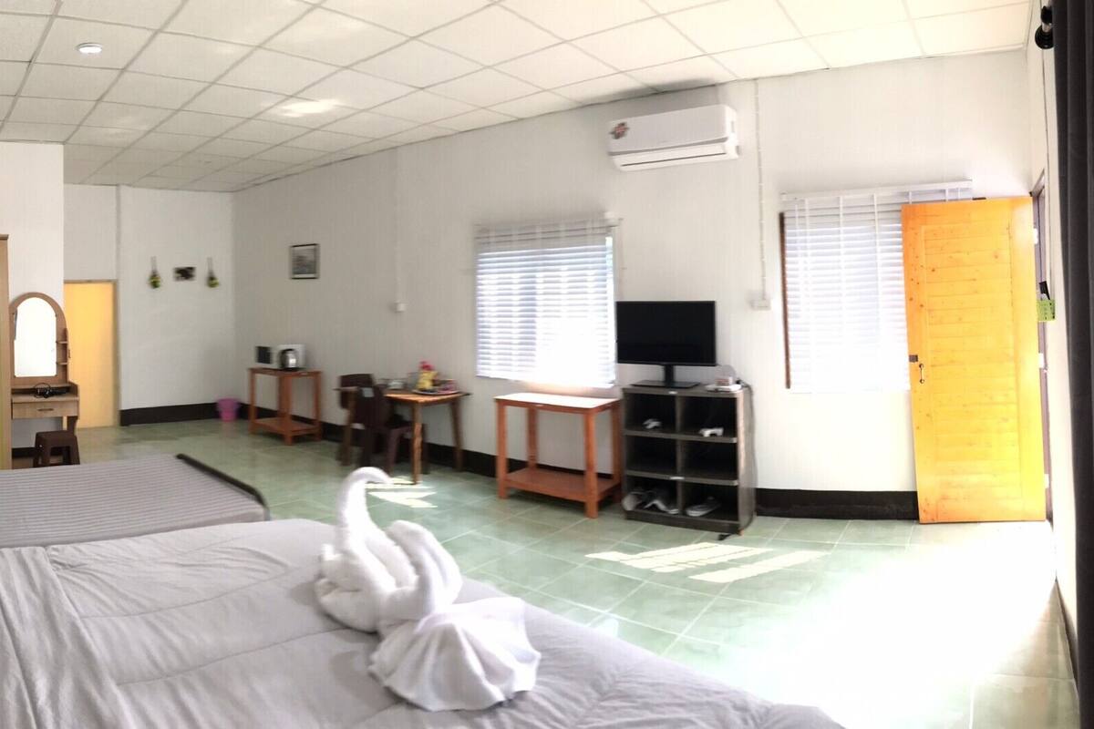Une chambre d’hôtel avec deux lits, un bureau, une télévision et une armoire.