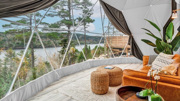 Un hébergement en tente offrant une vue sur un lac et une forêt.