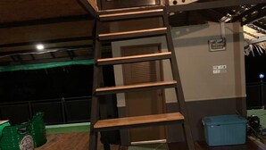 A wooden spiral staircase in a room with a high ceiling and exposed beams. - Cozy, friendly, surroundings with nature ,Thai culture and  life style. (Nasuan Srisawat)