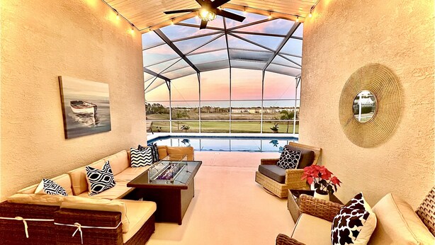 Un patio espacioso con techo de vidrio, mobiliario exterior y vistas a un campo de golf.
