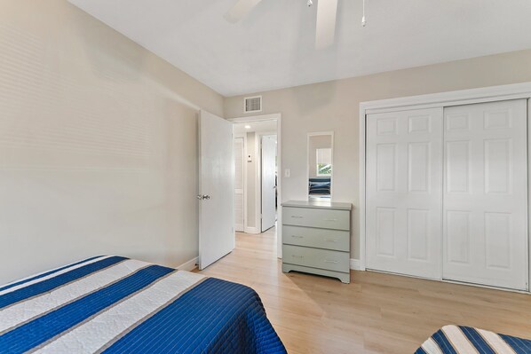 A bedroom with a bed, a dresser, and a wardrobe.