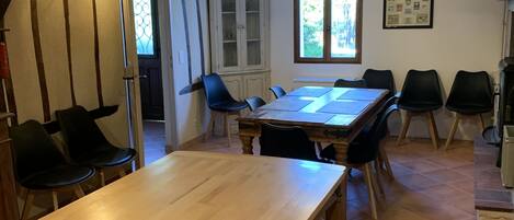 A dining area with a wooden table and chairs, a cabinet, and a window with a view.