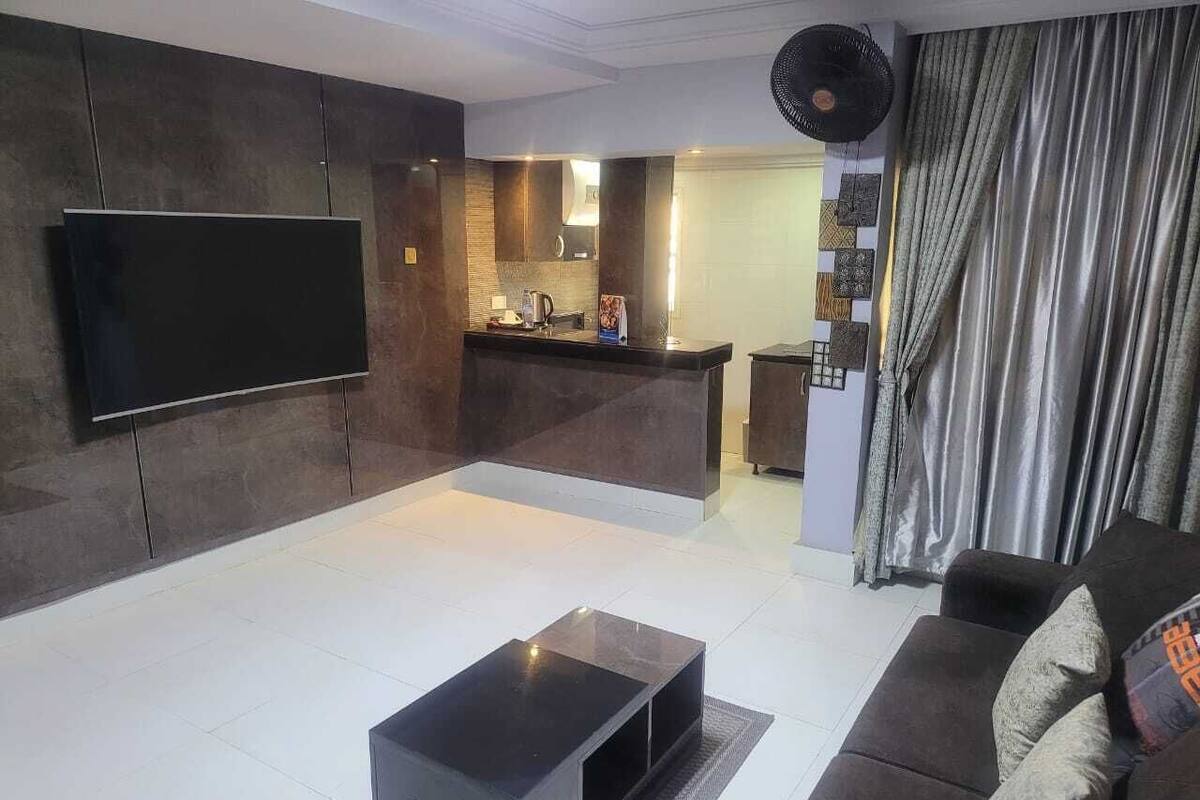 A modern living room with a flat-screen TV, a coffee table, and a sofa.
