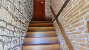 Un escalier avec des marches en bois et une rampe en bois, menant à une porte en bois.