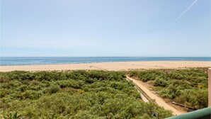 A beach with a dirt path leading to a structure, surrounded by dense greenery. - Stunning apartment in Ayamonte with swimming pool (Ayamonte)