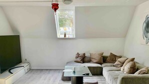 A modern living room with a sectional sofa, a coffee table, and a TV.