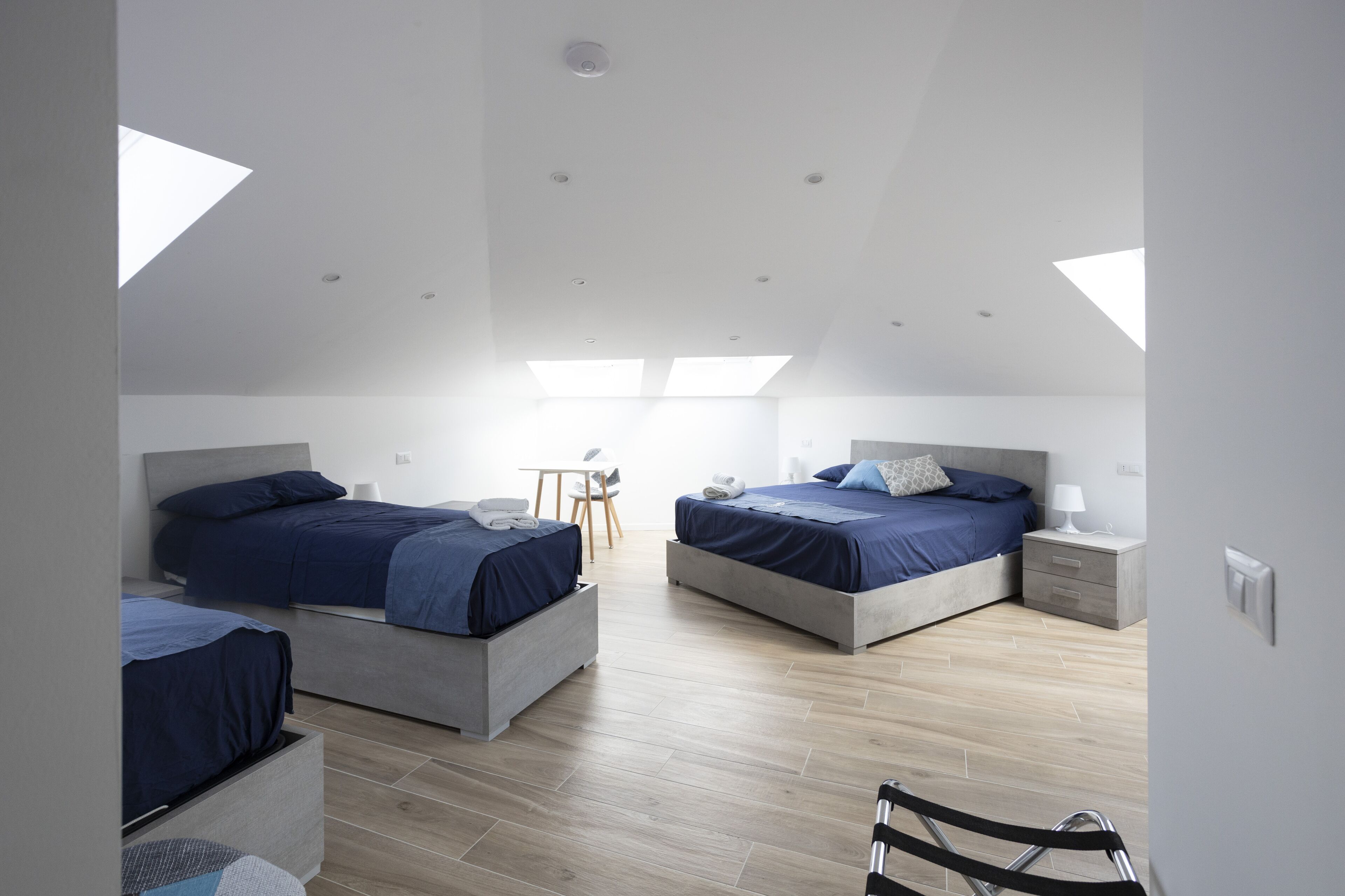 Une chambre moderne avec deux lits, un bureau et une chaise.