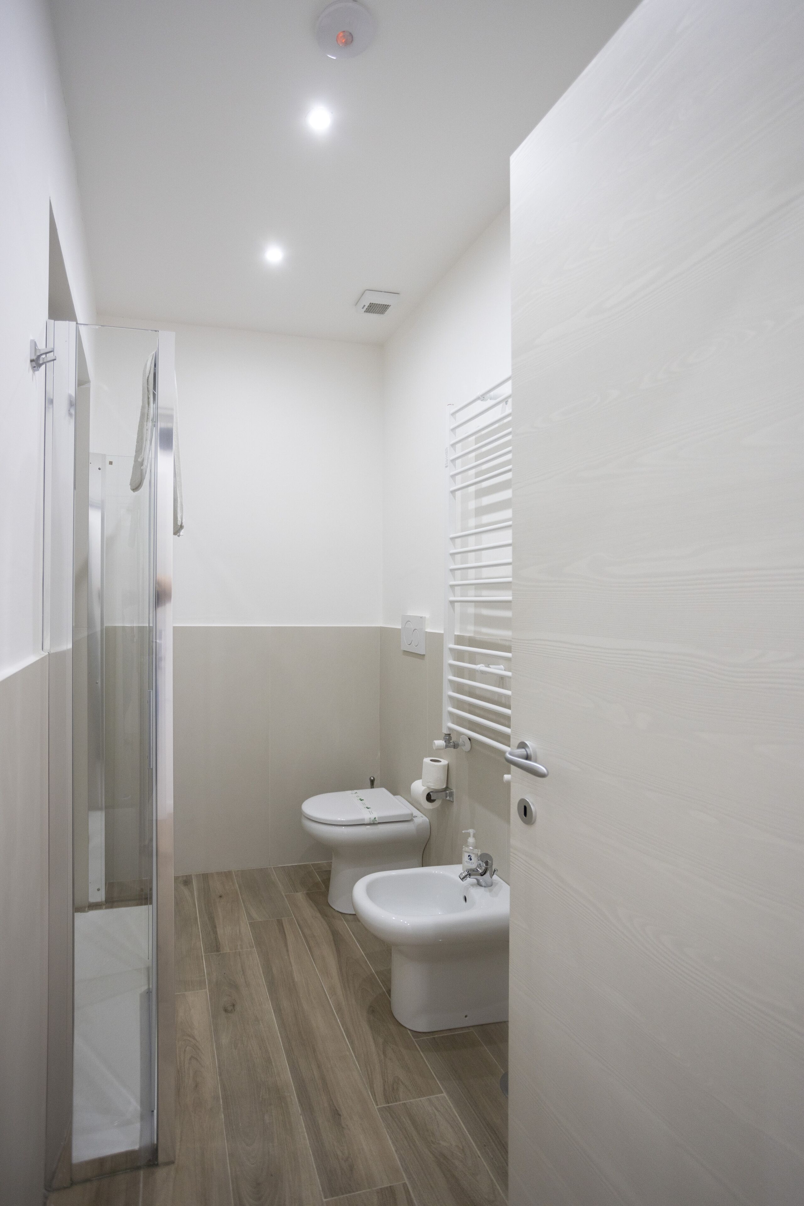 Un baño con cabina de ducha de vidrio, inodoro y bidé.
