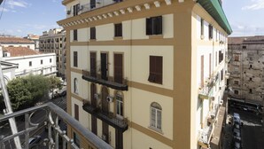 A multi-story building with balconies, a street view, and a clear sky. - GIULY SUITES & ROOMS (Naples)