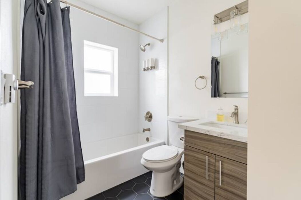 Un baño moderno con bañera, inodoro y tocador.