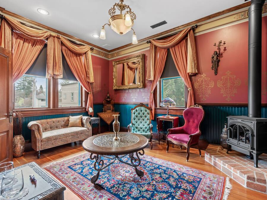 Une pièce au décor traditionnel, avec un canapé, un fauteuil et une table agrémentée d’un vase.
