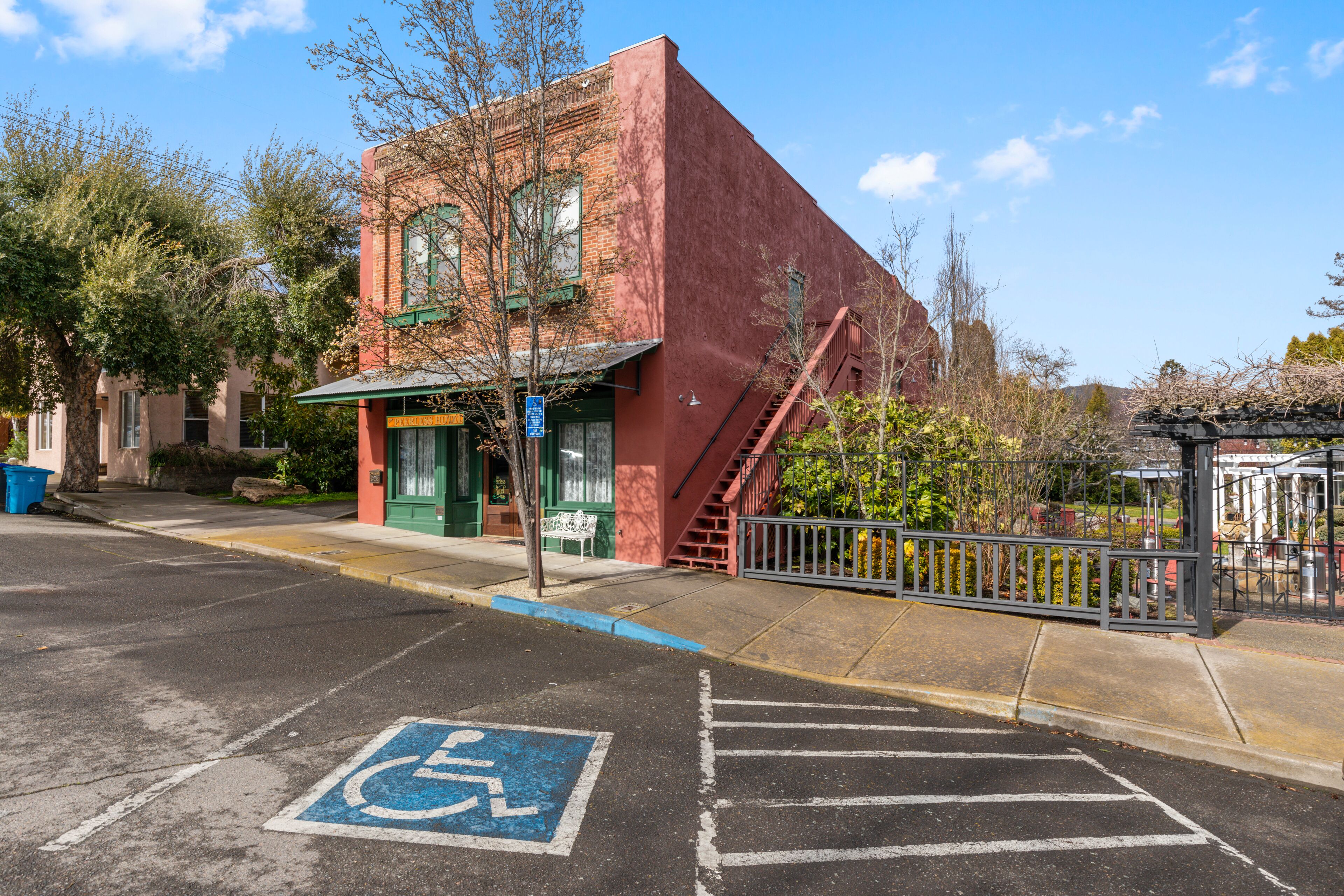A red brick building with a green awning and a wheelchair-accessible parking space.