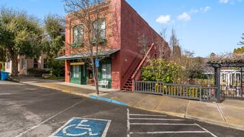 A red brick building with a green awning and a wheelchair-accessible parking space.