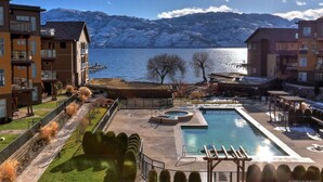 Zona residencial con piscina, vista a un lago y montañas al fondo.