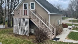 Une maison de plain-pied avec un porche à l’avant et un petit escalier menant à une terrasse.
