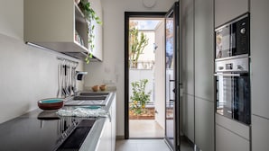 A modern kitchen with built-in appliances, a sink, and a countertop with bowls and utensils. - Mondello, Villa Blu with swimming pool (7 min from the beach) (Palermo)