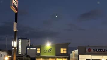 Un motel con un letrero visible, un concesionario Suzuki y un cielo despejado.