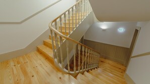 A wooden staircase with a white railing and a light switch on the wall. - Legacy Oporto Design Apartment G by Vacationy (Porto)