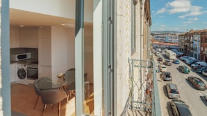 Eine moderne Wohnung mit Balkon, Küche und Blick auf eine belebte Straße.