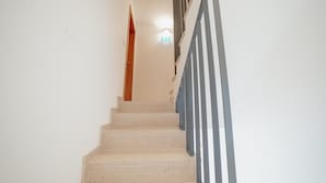 A staircase with beige steps and a striped handrail.