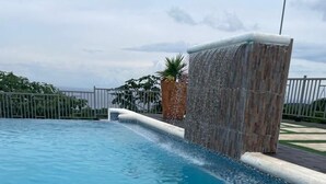 Ein Pool mit Steinmauer und einem kleinen Wasserfall.