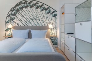 A neatly made bed with white linens and a headboard featuring a geometric design.