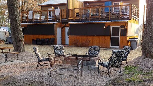 Una cabaña de madera con terraza y zona de estar al aire libre.