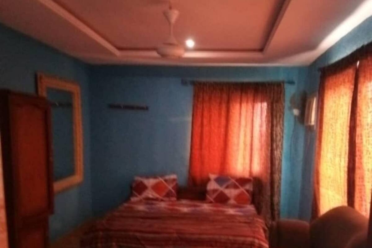 Une pièce comprenant un lit, une chaise, une table et une armoire.