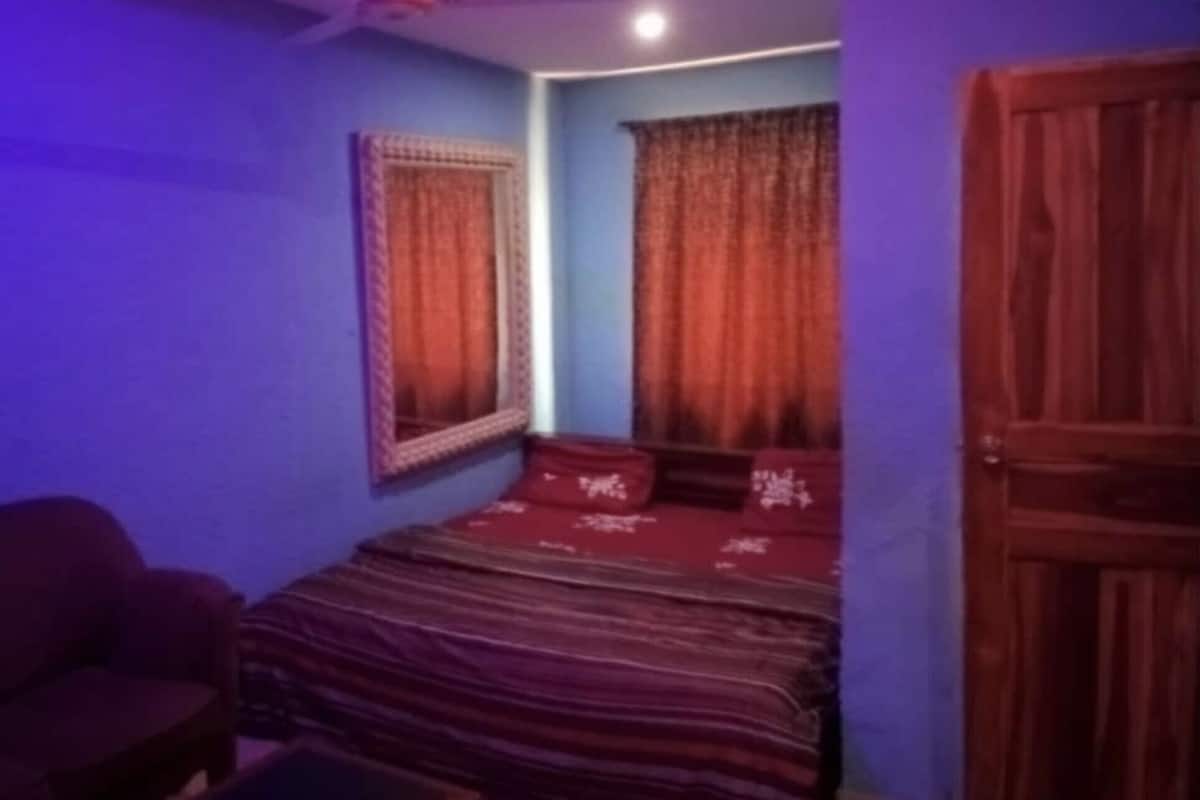 Une chambre à coucher avec un lit, une chaise et une porte.