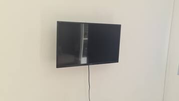 A flat-screen TV mounted on a wall with a visible power cord.
