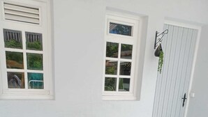 Un espacio patio con mobiliario de mimbre, una mesita y plantas en macetas.