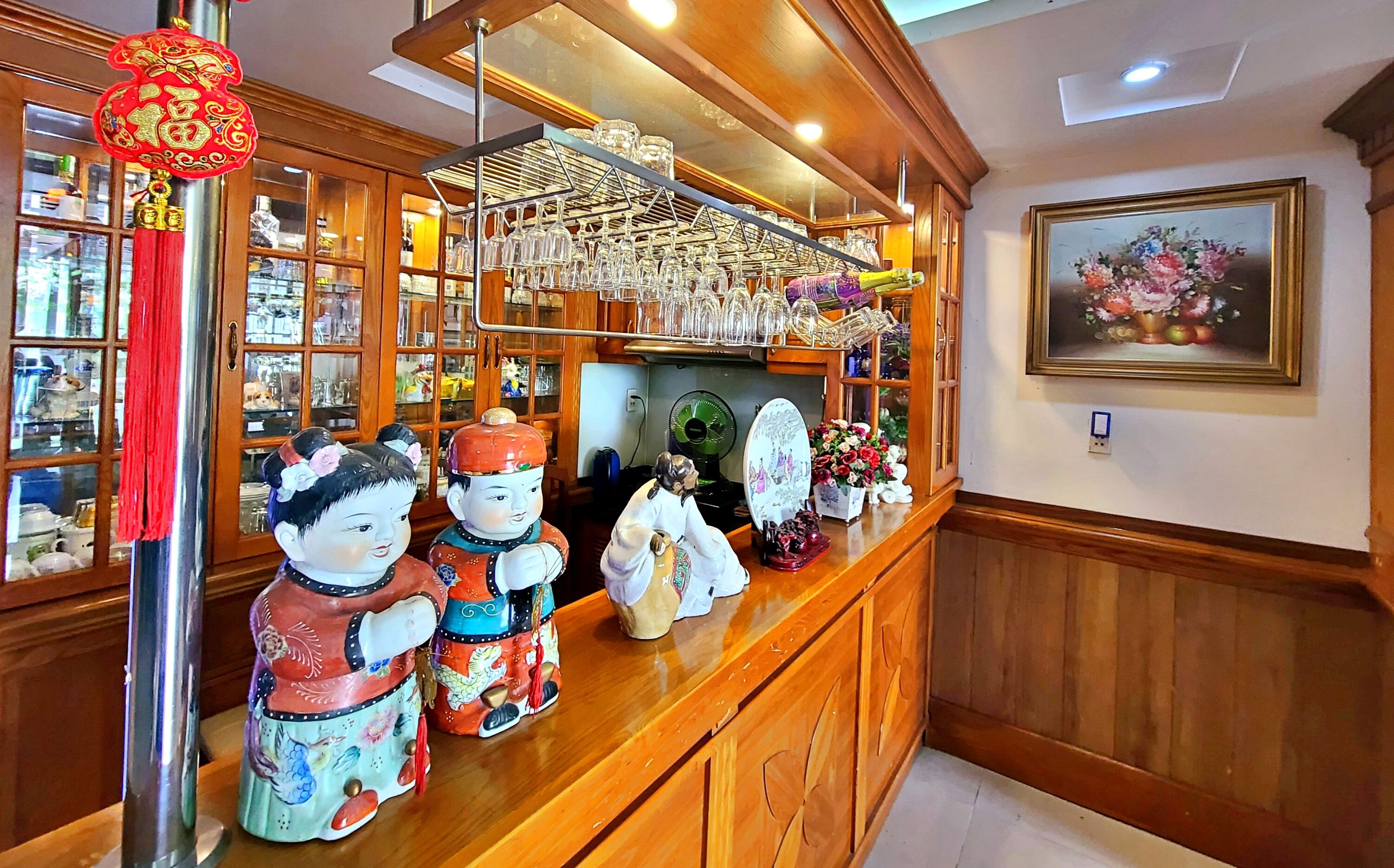 A bar area with a wooden counter, glassware, and decorative items.