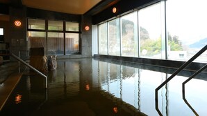An indoor swimming pool with clear glass walls, a wooden ceiling, and a view of the outdoors. - Ooedo Onsen Monogatari Kounkaku (Osaki)