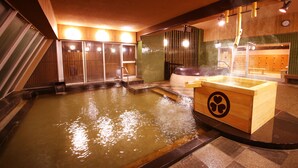 A hot spring bath area with wooden benches and a tiled wall. - Ooedo Onsen Monogatari Masuya (Osaki)