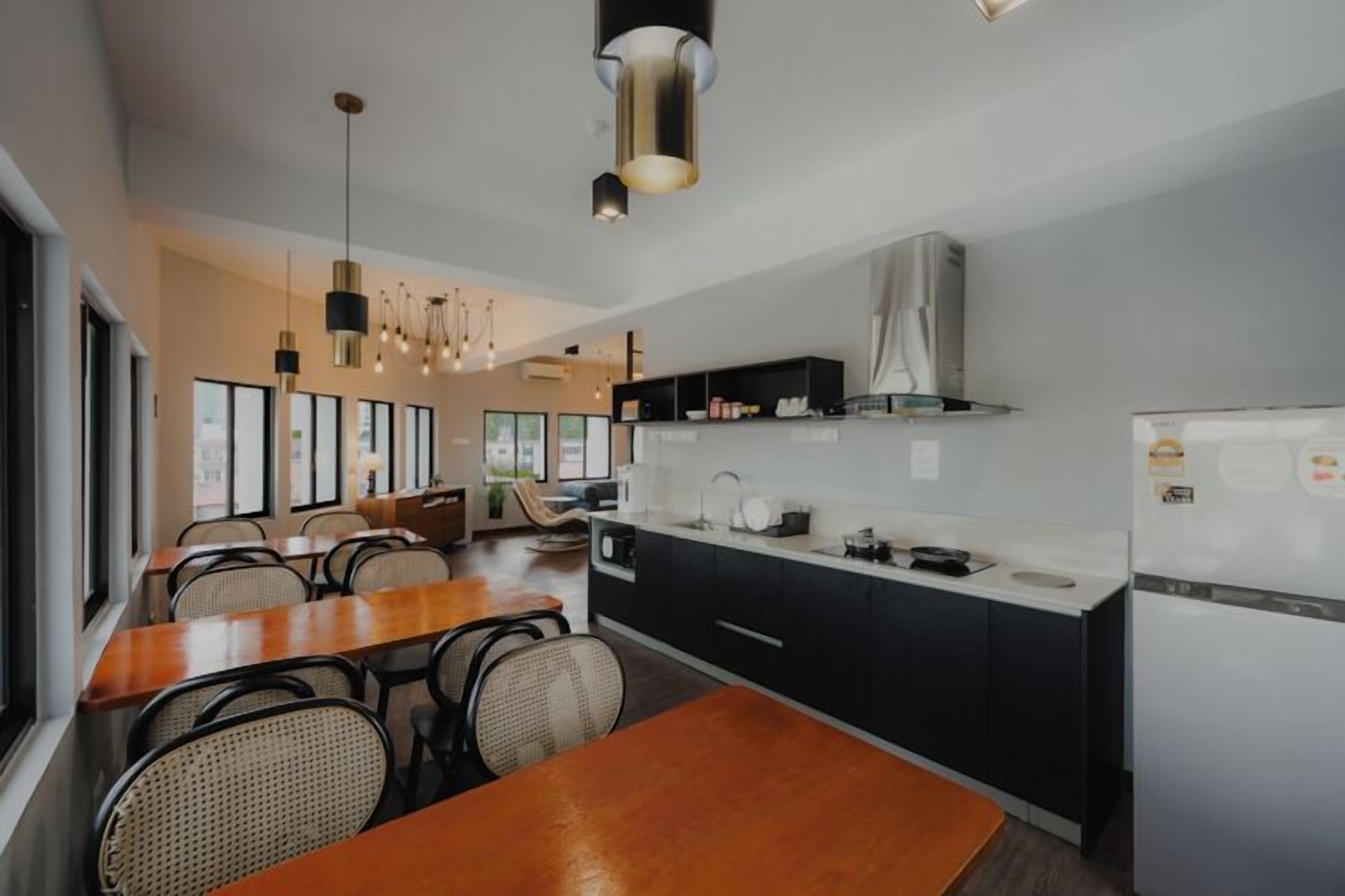 A modern kitchen with a dining area, featuring a wooden table, chairs, and pendant lighting.