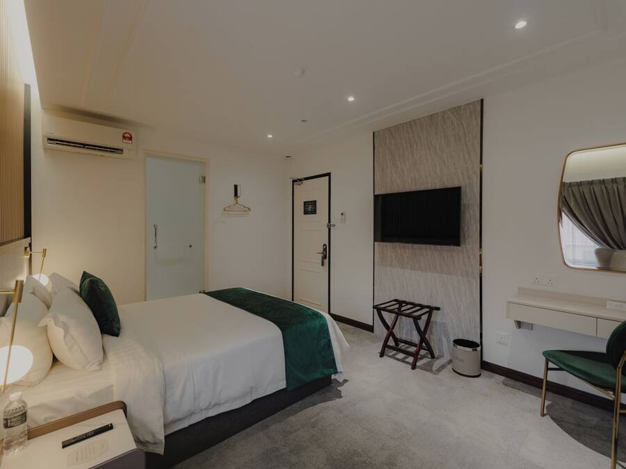 Una moderna camera d'albergo con un letto grande, una scrivania, una sedia, una televisione e uno specchio.