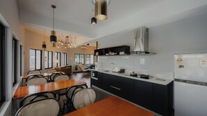 Een moderne keuken met zwart-wit keukenkastjes, een houten eettafel en hanglampen.