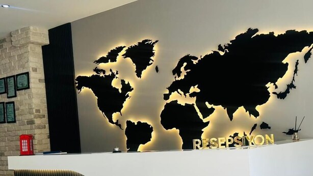 Un mostrador de recepción con un diseño de mapa mundial, un letrero que dice 'pars' y un teléfono rojo.