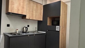 Una cocina compacta con muebles oscuros, una pequeña isla y una mesa de comedor.