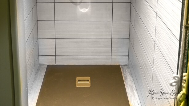 A shower with a handheld showerhead, a wall-mounted faucet, and a control panel. - Casa Upupa  (Montreuil)